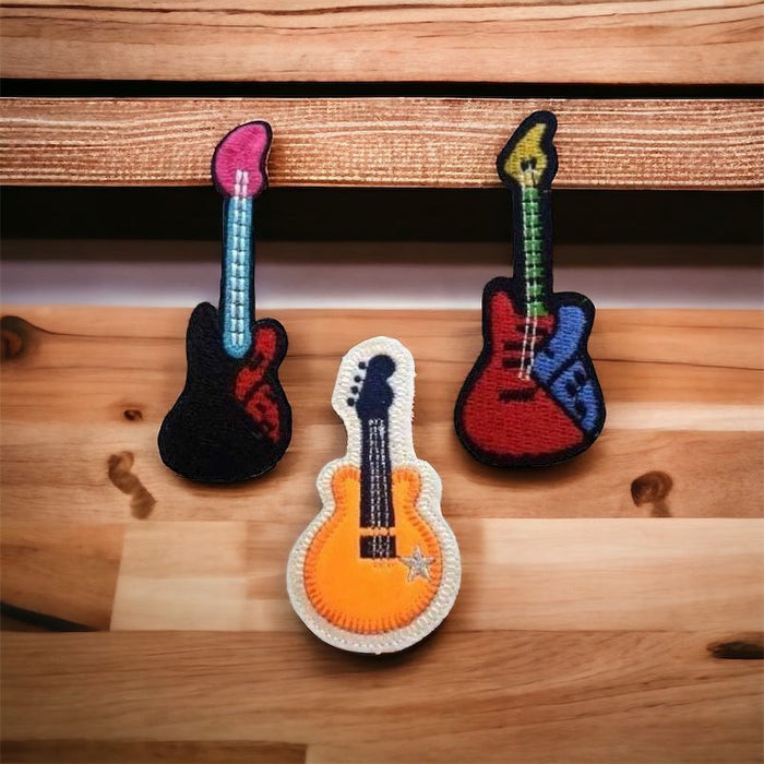 Electric and acoustic guitar themed music patches on a wooden table