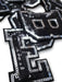 Black and silver sequin iron on patch letters close-up of letter E