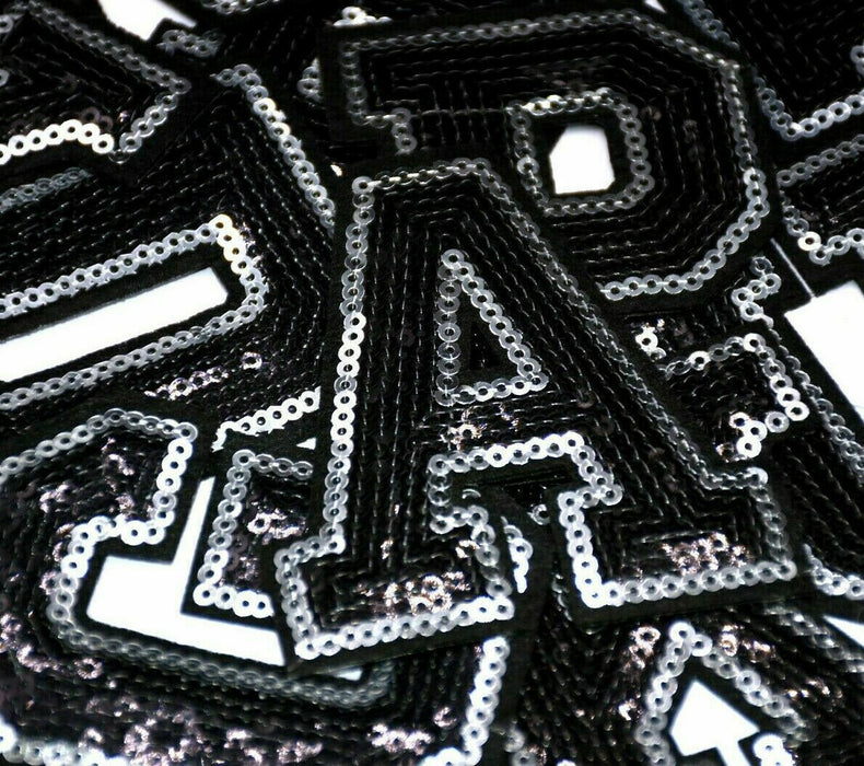 Black and silver sequin iron on patch letters, close up of letter A on other letters