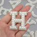 White pearl silver rhinestone iron-on patch letters showing a closeup of the letter H..