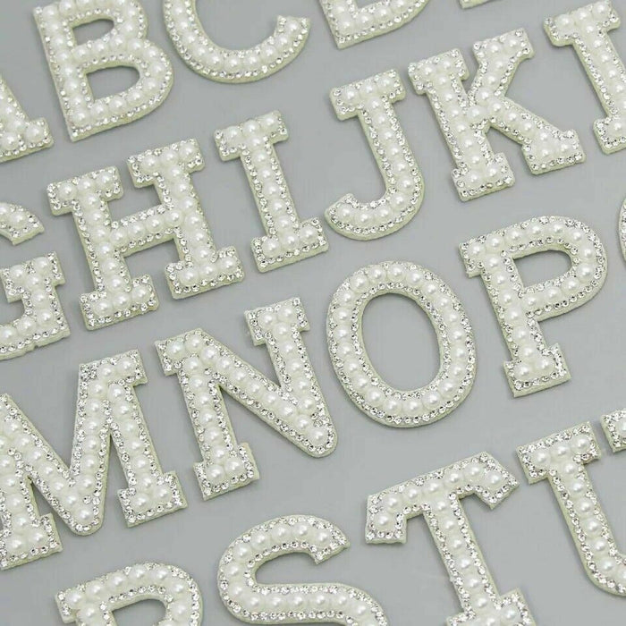 White pearl silver rhinestone iron-on patch letters showing a section of the alphabet. Used by brides for wedding party attire and personalising clothing.